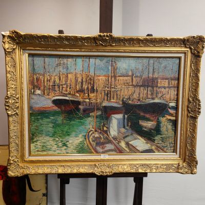 une photo d'un tableau posé sur un chevalet, avec un bateau dans l'eau