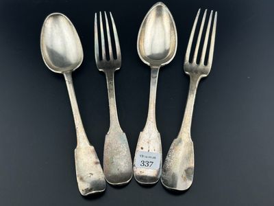 trois cuillères en argent et deux fourchettes en argent posées sur un fond noir