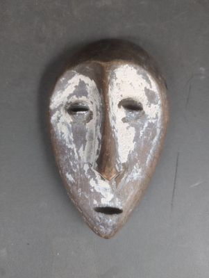 un masque accroché au mur d'un immeuble