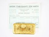 a gold bar sitting on top of a piece of paper
