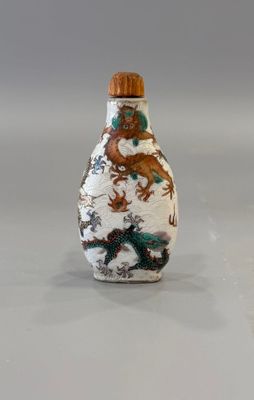 une petite bouteille ornée d'un dragon, posée sur une table
