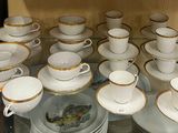 beaucoup de tasses et de soucoupes posées sur une table en verre
