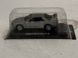 a toy car in a clear case on a white surface