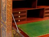 a desk with a green top and a gold trim
