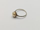 a close up of a silver ring with a pearl on it