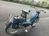 a blue moped that is parked on the side of the road