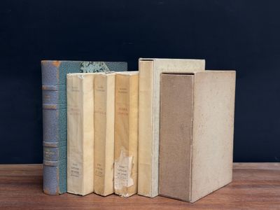 three books are stacked on top of each other on a wooden table