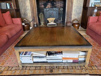 a coffee table in the middle of a living room with red couches