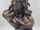 bronze bust of a man with curly hair on a wooden base