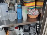a stainless steel shelf with dishes and cups on it