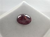 a close up of a red diamond on a white surface
