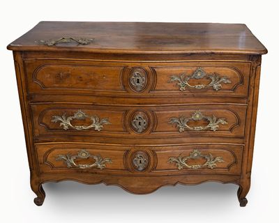 Commode en noyer mouluré sculpté à façade légèrement galbée …