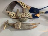 two knives and a belt on display on a table