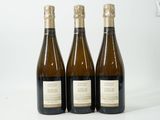 trois bouteilles de vin posées les unes à côté des autres sur une surface blanche