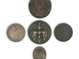 six different coins are arranged in a circle on a white surface