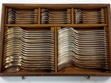 many spoons and forks in a wooden box