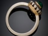 a close up of a ring with a green stone in it
