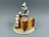 une figurine représentant un chat et un chien assis sur une boîte