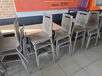 des tables et des chaises dans un restaurant, avec un mur en briques en arrière-plan