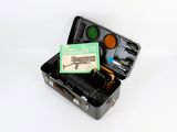 a black suitcase with a green label and a book in it