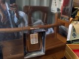 reflet d'une femme dans un miroir posé sur un bureau où se trouve une cafetière
