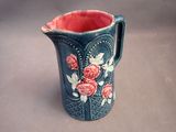 a blue vase with red roses on it on a table