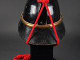 a black helmet with a red string tied to it
