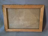 an old picture frame with a piece of linen hanging from it