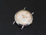 a silver watch with a white face on a black surface