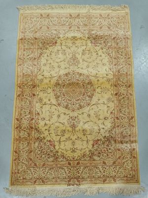 an antique persian rug with a floral design on a beige ground