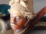 a statue of a woman with a hat and a pipe