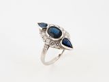 a close up of a ring with a blue stone and diamonds