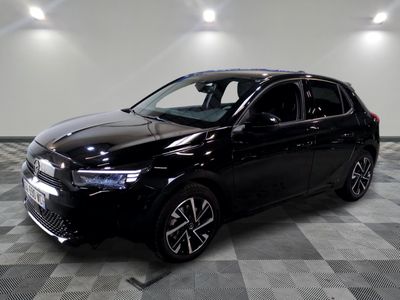 la voiture noire est garée sur un sol en damier dans le garage