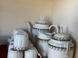 a shelf with a bunch of tea pots and cups on it
