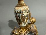a gold vase with a dog on it on a table