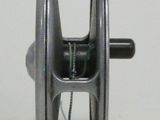a close up of a fishing reel on a white surface