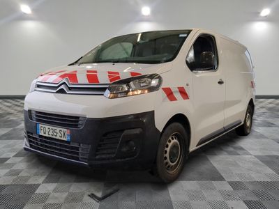 une camionnette Citroën à rayures rouges et blanches garée dans une grande pièce