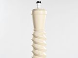 a tall white vase with a black top and a white base