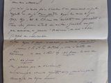 une vieille lettre manuscrite, posée sur un morceau de papier, sur une table