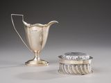 two silver vases and a silver container on a white surface