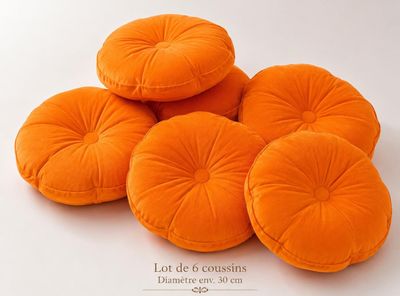 four orange round cushions sitting on top of each other on a white surface