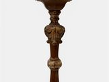 an old wooden candle holder with a candle on top of it