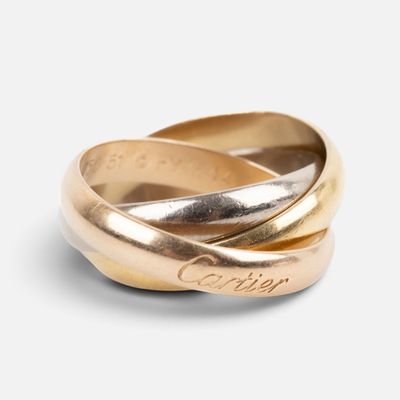 a close up of two gold rings on a white surface
