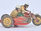 a figurine of a man riding a motorcycle with a dog on the back