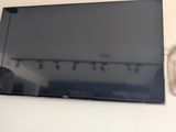 une télévision à écran plat accrochée au mur au-dessus d'une lampe