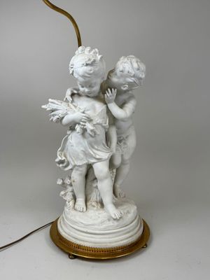 une image représentant une lampe sur laquelle se trouve une statue de deux enfants