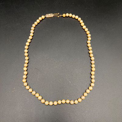 un collier de perles jaunes sur un fond noir
