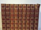 several old books are lined up in a row on a white surface