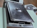 un four en argent posé sur une table dans une pièce