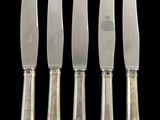 four knives are lined up in a row on a black background